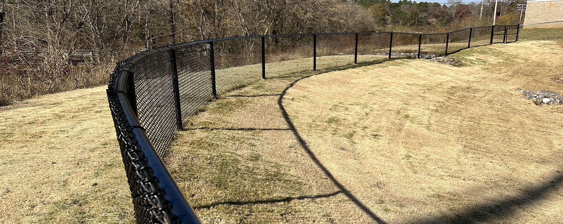 Black round fence tubing used in a chain link fence